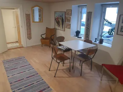 a dining room with a table and chairs at Stor lejlighed ved togstation in Viborg