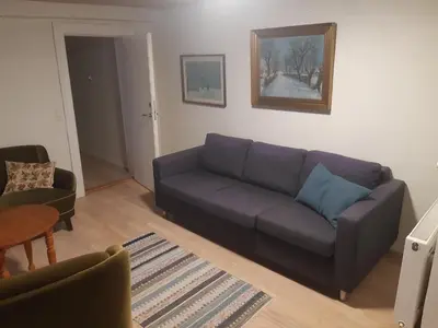 a living room with a purple couch and a table at Stor lejlighed ved togstation in Viborg