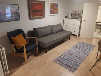 a living room with a couch and a chair at Stor lejlighed ved togstation in Viborg