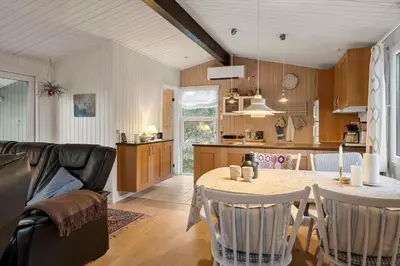 a kitchen and living room with a table and chairs at 1371-Thisted-Havtornvej-1 in Nørre Vorupør
