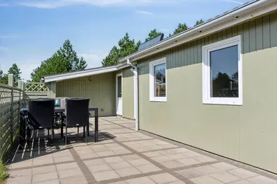 a patio with a table and chairs next to a house at 1371-Thisted-Havtornvej-1 in Nørre Vorupør