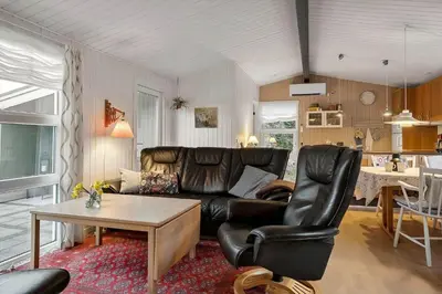 a living room with a leather couch and a table at 1371-Thisted-Havtornvej-1 in Nørre Vorupør