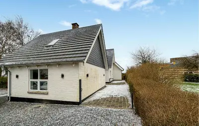 a white building with a gray roof on a driveway at Stunning Apartment In Roslev With Wifi in Roslev