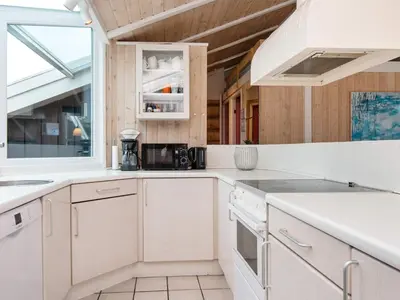 a kitchen with white cabinets and a window at 4 star holiday home in Løkken in Løkken
