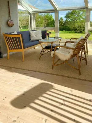 a living room with a couch and a table and chairs at Cozy Holiday Home With Fjord Views On Fur in Fur