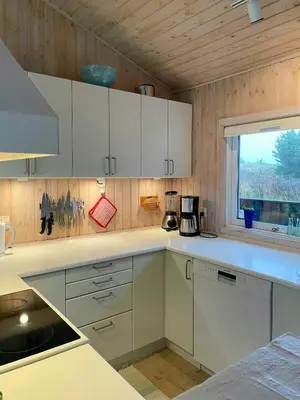a kitchen with white cabinets and a window at Summer House With Views Over Jammerbugt in Saltum