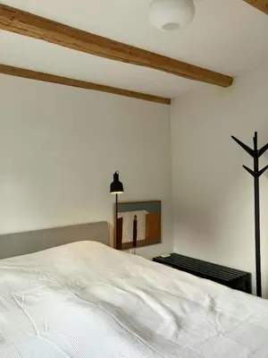 a bedroom with a white bed and a cross on the wall at Restored Fisherman's House On Cliff In Thy in Hanstholm