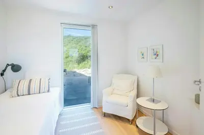 a white living room with a white couch and a chair at Thatched House At First Dune Row In Blokhus in Blokhus