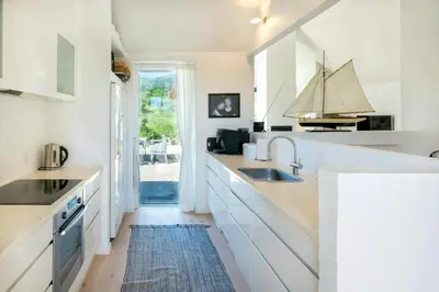 a white kitchen with a sink and a window at Thatched House At First Dune Row In Blokhus in Blokhus