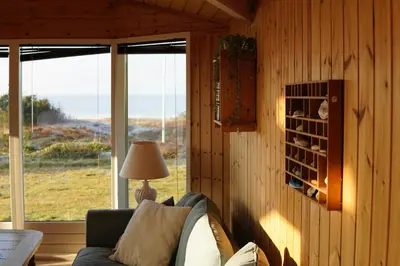 a living room with a couch and some windows at Holiday Home With Private Beach Trail And Sea View in Trend