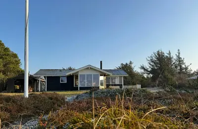 a house on the beach with a pole at Holiday Home With Private Beach Trail And Sea View in Trend