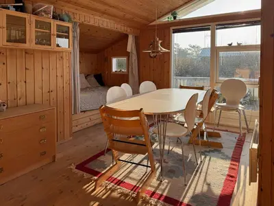 a dining room with a table and chairs and a bedroom at Holiday Home With Private Beach Trail And Sea View in Trend