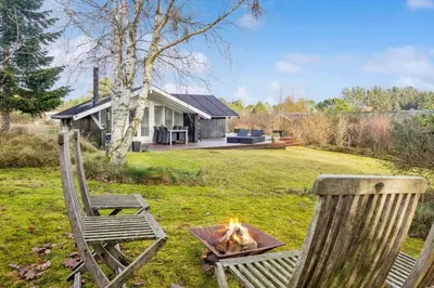 two chairs and a fire pit in a yard at BL1155-Blokhus-Berberisvej-74 in Blokhus