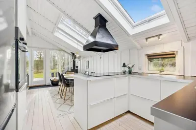 a kitchen with white cabinets and a skylight at BL1155-Blokhus-Berberisvej-74 in Blokhus