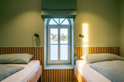 two beds in a room with a window at Historic Farm And Surf Shack At Cold Hawaii in Thisted
