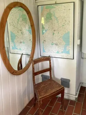 a mirror and a wooden chair next to a wall at Historic House From 1887 Near Nationalpark Thy
