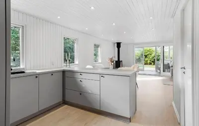 a white kitchen with white cabinets and windows at Nice Home In Farsø With House A Panoramic View in Farsø