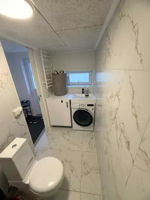 a small bathroom with a toilet and a sink at Hel hus i rolig by in Birkelse