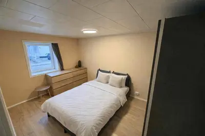 a small bedroom with a bed and a window at Hel hus i rolig by in Birkelse