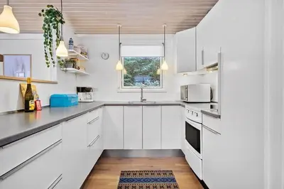 a white kitchen with white cabinets and a window at BL1154-Blokhus-Kornblomstvej-22 in Blokhus