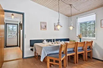 a dining room with a table and chairs at BL1154-Blokhus-Kornblomstvej-22 in Blokhus