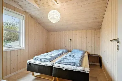 a bed in a corner of a room with a window at JB406-Fjerritslev-Aspevej-68 in Fjerritslev