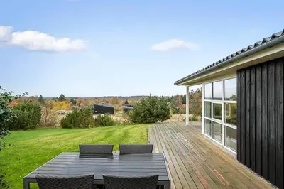 a patio with a table and chairs on a deck at JB406-Fjerritslev-Aspevej-68 in Fjerritslev