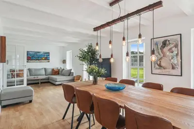a dining room with a large wooden table and chairs at Holstvej 21 in Blokhus