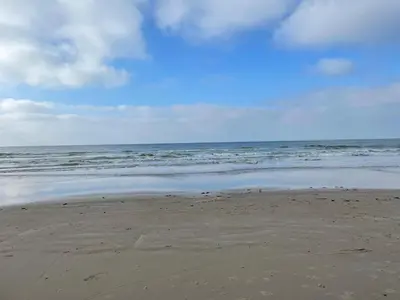 a sandy beach with the ocean in the background at Søndergade 21, Lejl 3 in Løkken