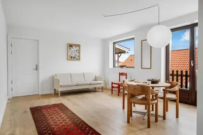 a white living room with a table and chairs at Søndergade 21, Lejl 3 in Løkken