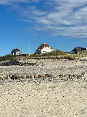 a beach with houses on top of a hill at Søndergade 21, Lejl 3 in Løkken