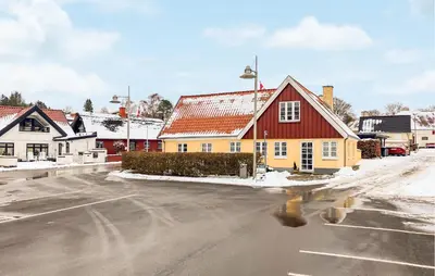 a yellow and red building on a street with snow at Nice Home In Løgstrup With Wifi in Løgstrup