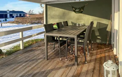 a wooden table and chairs on a deck at 3 Bedroom Awesome Home In Farsø in Farsø