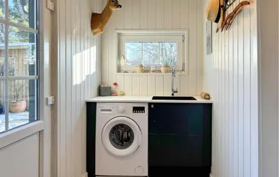 a washer and dryer in a laundry room with a window at 3 Bedroom Awesome Home In Farsø in Farsø