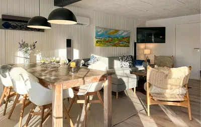 a living room with a wooden table and chairs at 3 Bedroom Awesome Home In Farsø in Farsø