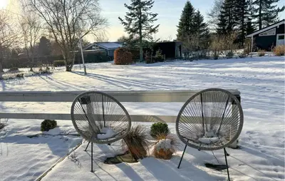 two chairs in the snow next to a bench at 3 Bedroom Awesome Home In Farsø in Farsø