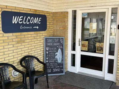 a sign on the side of a store with a bench at VØ Budget Drop Inn in Thisted