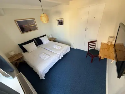 a small bedroom with a bed and a chair at VØ Budget Drop Inn in Thisted