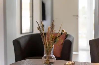 a vase with flowers sitting on a table at Feriecenter Slettestrand in Fjerritslev