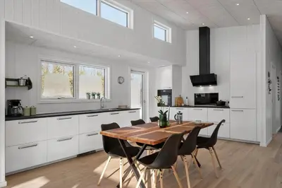 a kitchen with a wooden table and black chairs at JB376-Fjerritslev-Egevej-14