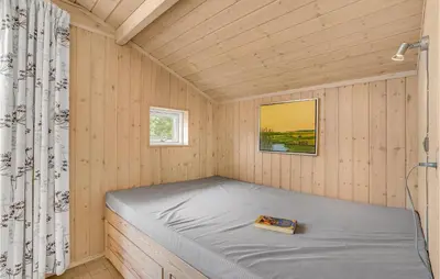 a small bedroom with a bed in a tiny house at Holiday Home Hurup Thy With A Fireplace 06 in Heltborg