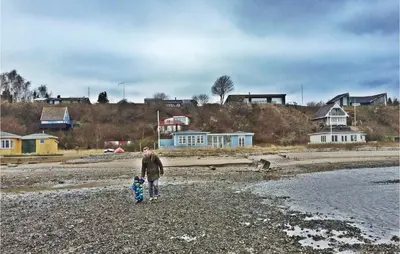 a man walking on the beach with a child at Holiday Home Roslev With A Fireplace 01 in Roslev