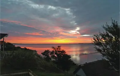 a sunset over a body of water with a bridge at Holiday Home Roslev With A Fireplace 01 in Roslev