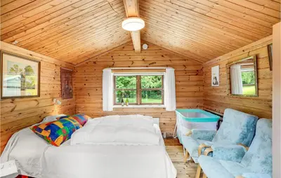 a bedroom with a bed and a couch and a window at Nørklit in Frøstrup