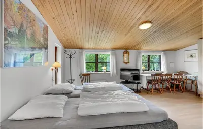 a bedroom with two beds and a dining room at Nørklit in Frøstrup