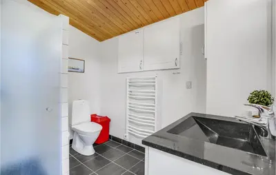 a white bathroom with a toilet and a sink at Nørklit in Frøstrup
