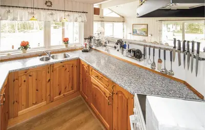 a kitchen with wooden cabinets and a counter top at Holiday Home Brovst With A Fireplace 03 in Brovst