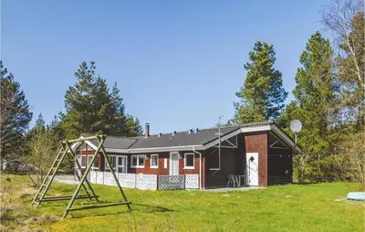 a house with a playground in front of it at Holiday Home Brovst With A Fireplace 03 in Brovst