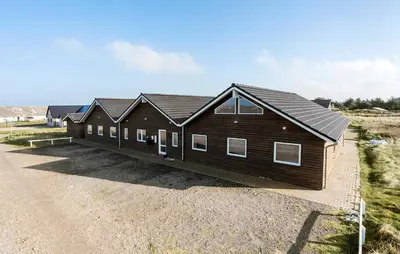 a large wooden house on a dirt road at Cozy Home In Harboøre With Kitchen in Harboør