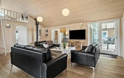 a living room with leather furniture and a flat screen tv at Cozy Home In Harboøre With Kitchen in Harboør